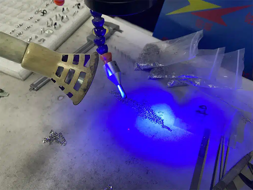 Blue light illuminating jewelry components held in a metal fixture