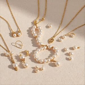Scattered collection of delicate gold jewelry including necklaces and small charms with crystal accents