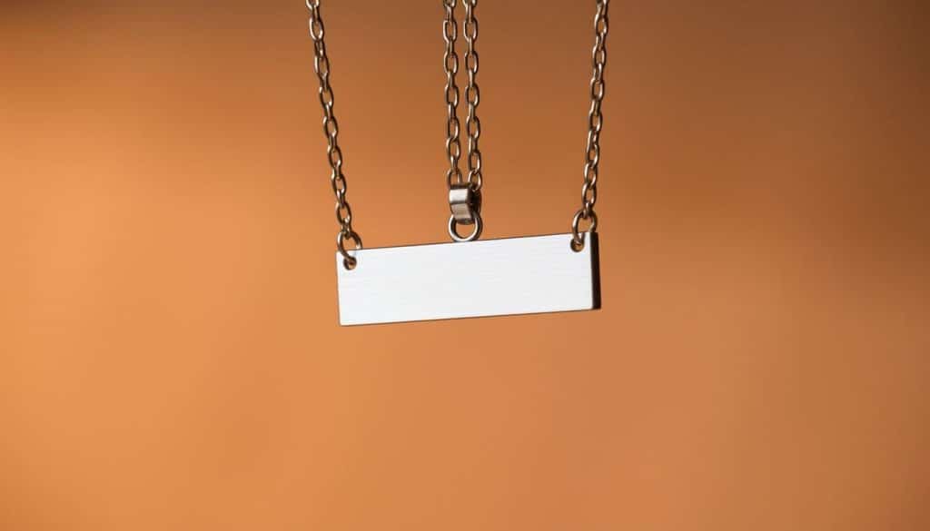 A stainless steel pendant necklace from the HonHo Jewelry collection, expertly crafted with a sleek and minimalist design. The pendant features a rectangular bar shape, polished to a brilliant shine, suspended from a delicate chain. The lighting casts a warm glow, highlighting the metal's natural luster and creating depth and dimension. Shot from a slightly elevated angle, the necklace is framed against a neutral, out-of-focus background, allowing the pendant to be the focal point. The overall mood is one of modern sophistication and timeless elegance, perfectly suited to illustrate the manufacturing process of customized stainless steel name bar necklaces.