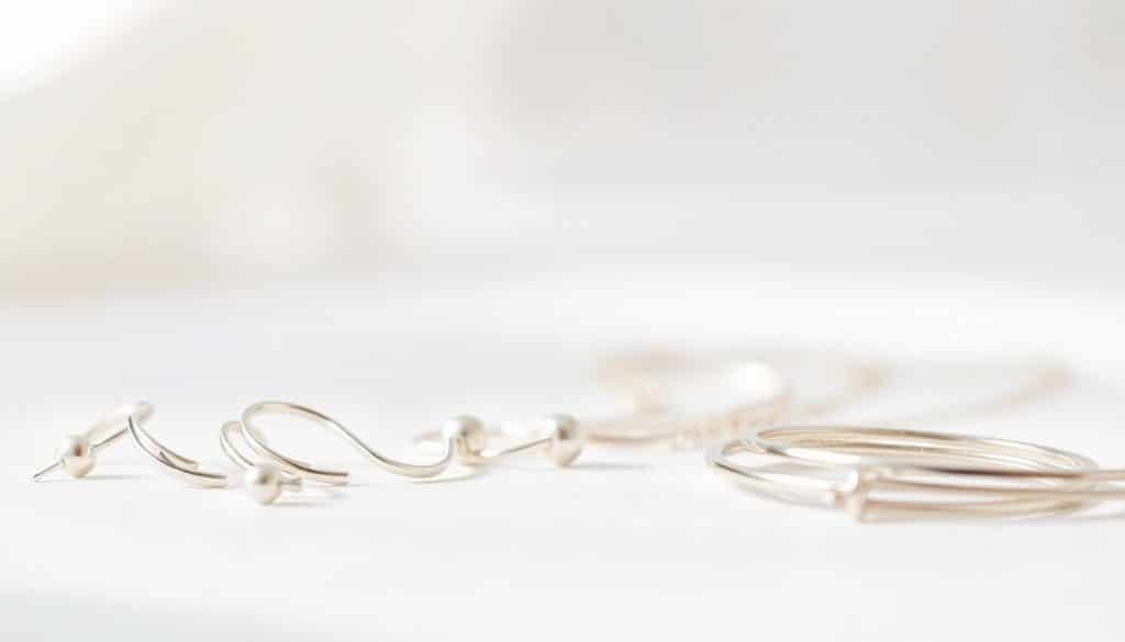 Nickel-Free Jewelry: a close-up, high-resolution photograph showcasing a selection of delicate, hypoallergenic jewelry pieces from the HonHo Jewelry brand. The foreground features a variety of elegant earrings, necklaces, and bracelets crafted from nickel-free metals like sterling silver, titanium, and stainless steel, with a subtle, natural lighting that highlights their shine and quality. The middle ground presents the jewelry against a clean, white background, allowing the pieces to be the focal point. The background is softly blurred, creating a sense of depth and focus. The overall mood is sophisticated, minimalist, and inviting, conveying the importance of choosing nickel-free jewelry options for those with metal sensitivities. Nickel-Free Jewelry: a close-up, high-resolution photograph showcasing a selection of delicate, hypoallergenic jewelry pieces from the HonHo Jewelry brand. The foreground features a variety of elegant earrings, necklaces, and bracelets crafted from nickel-free metals like sterling silver, titanium, and stainless steel, with a subtle, natural lighting that highlights their shine and quality. The middle ground presents the jewelry against a clean, white background, allowing the pieces to be the focal point. The background is softly blurred, creating a sense of depth and focus. The overall mood is sophisticated, minimalist, and inviting, conveying the importance of choosing nickel-free jewelry options for those with metal sensitivities.