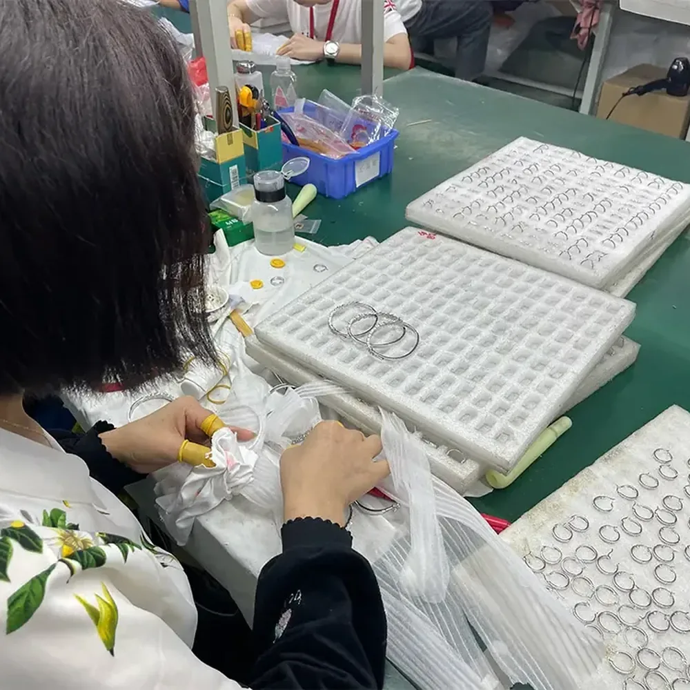 Does Brass Jewelry Tarnish? Finish-Specific Care Guide 2 Worker finishing hoop-shaped jewelry components at a polishing station