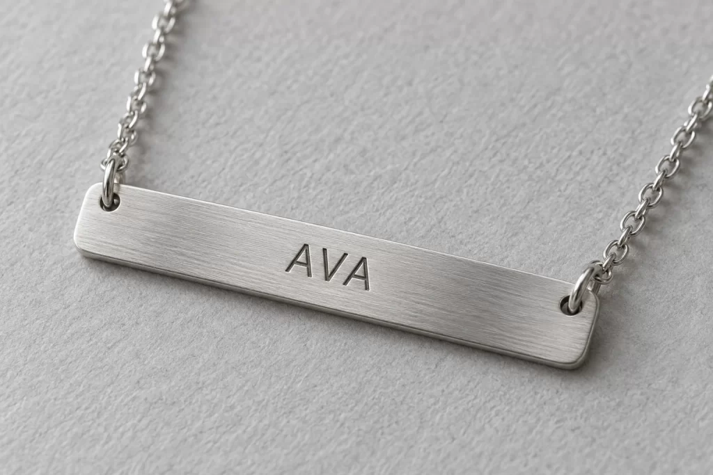 Custom Name Bar Necklaces: Engraving and Order Checklist 1 Brushed silver-colored name bar engraved AVA with two chain attachments