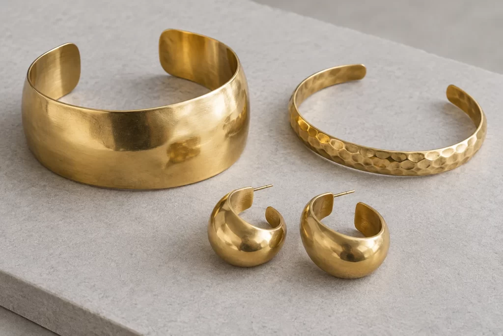 Brass Jewelry Wholesale: A Practical Buying Specification 1 Sculptural cuffs and hoop earrings in warm brass-like tones