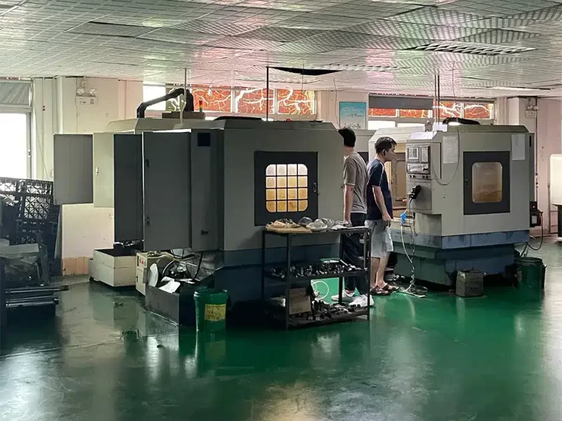 CNC machining area with operators working on high-tech machinery