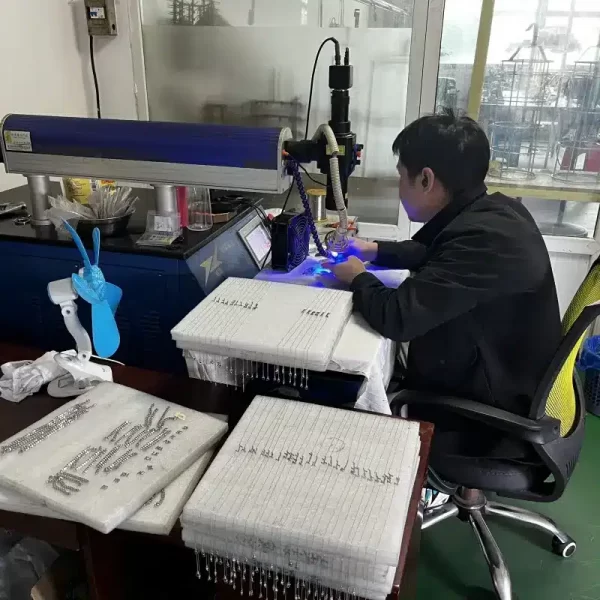 One of honho jewelry workers is making laser process for jewelry LOGO